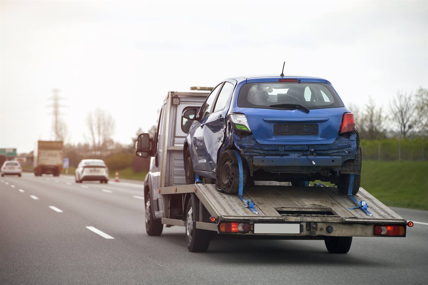 Veículo sendo transportado por um reboque na estrada